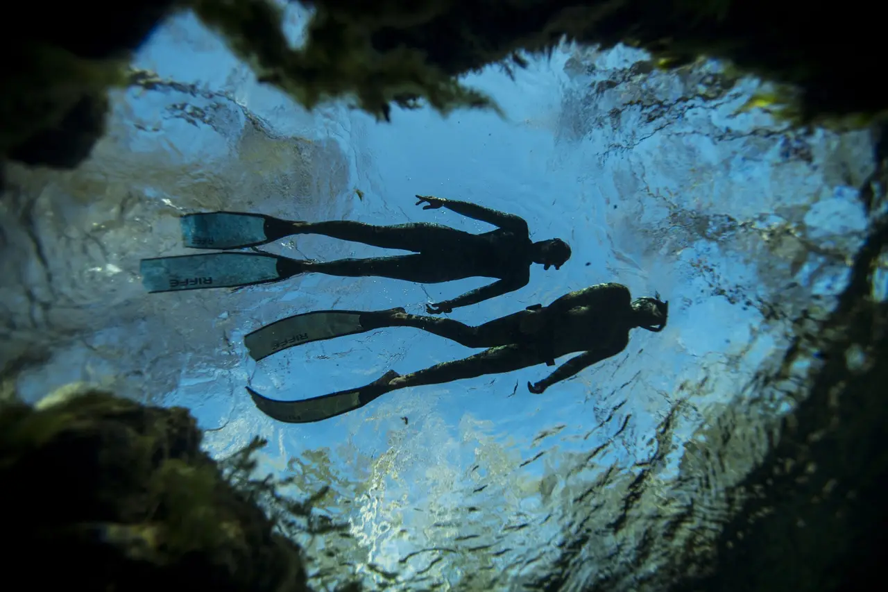 Un apnéiste descendant calmement sur une seule respiration dans les eaux claires et bleues de Boracay