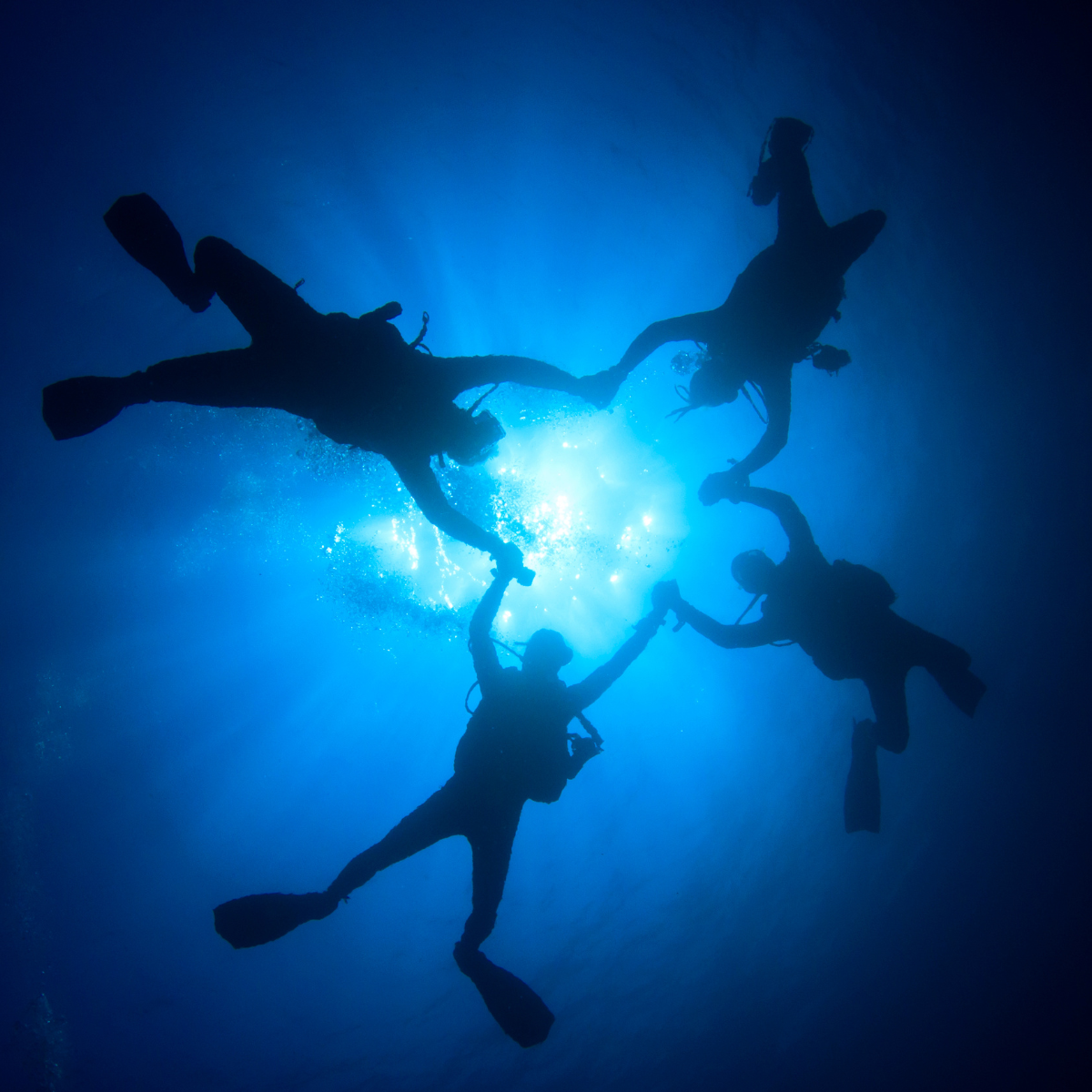 Three first-time divers discovering scuba together over a Boracay reef with their instructor
