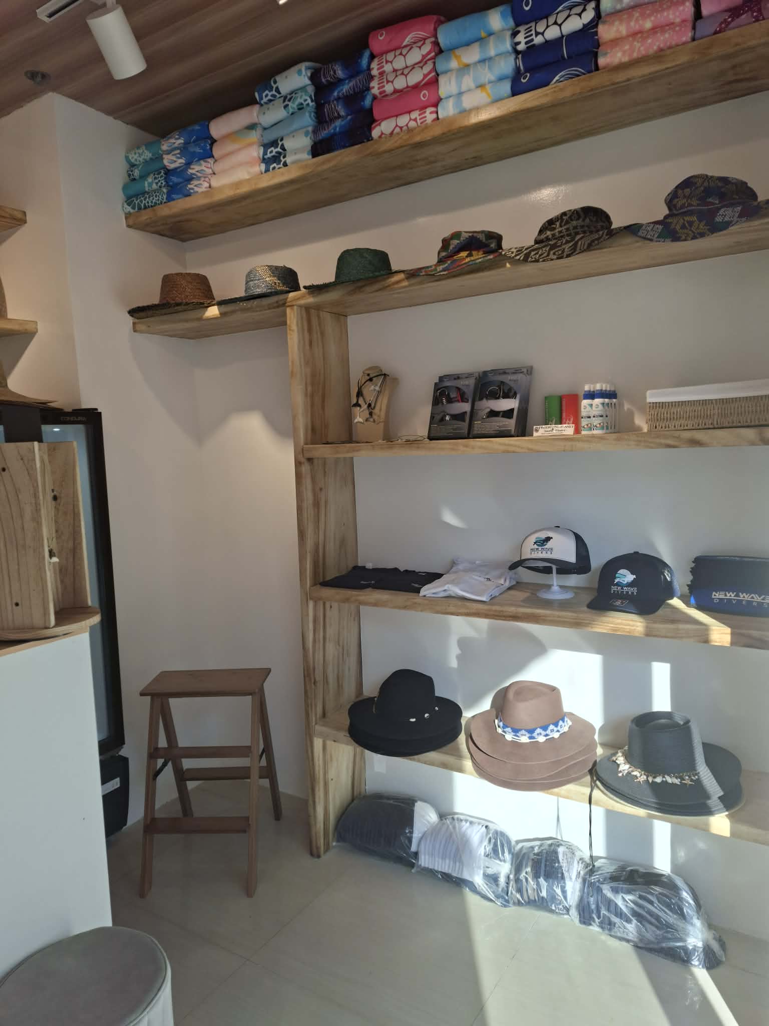 Hats, caps and beach towels on the shelves at New Wave Beach Boutique