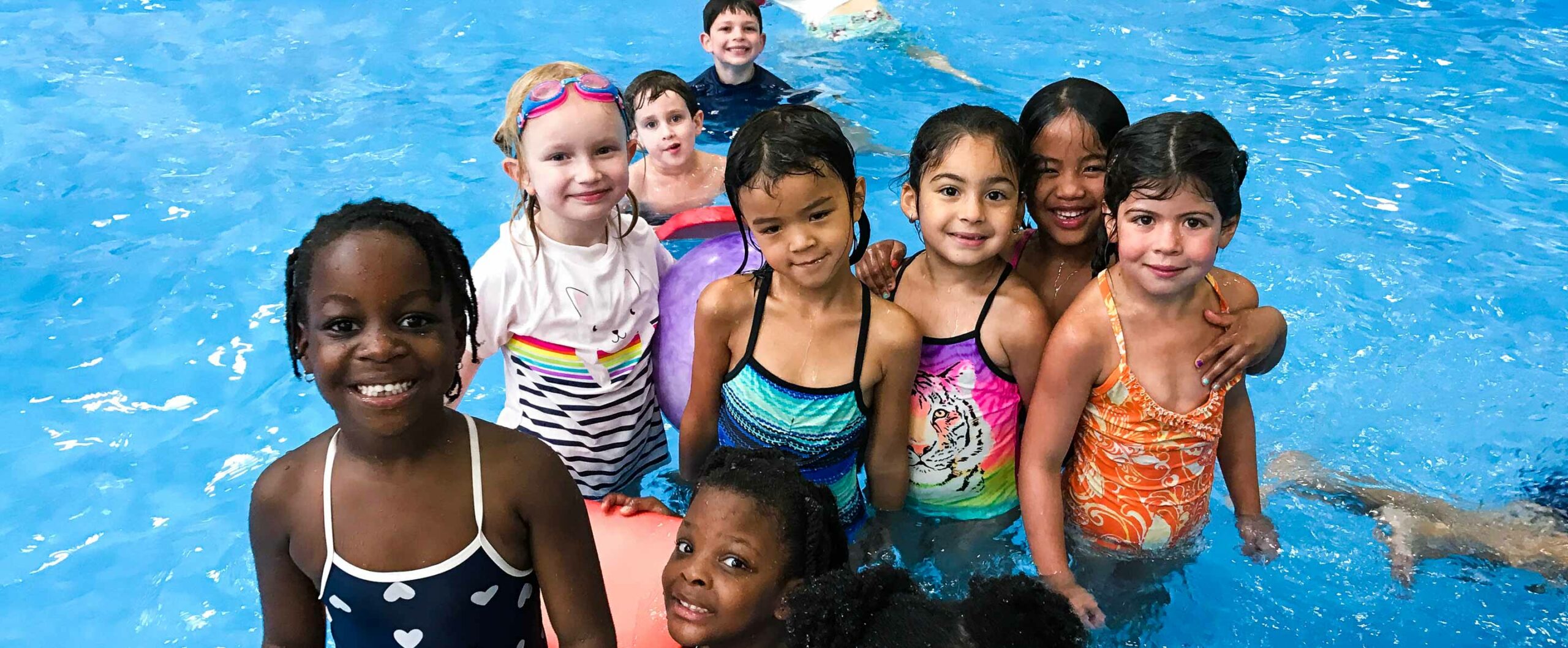 Kids splashing and playing in the pool at the New Wave Little Diver Camp
