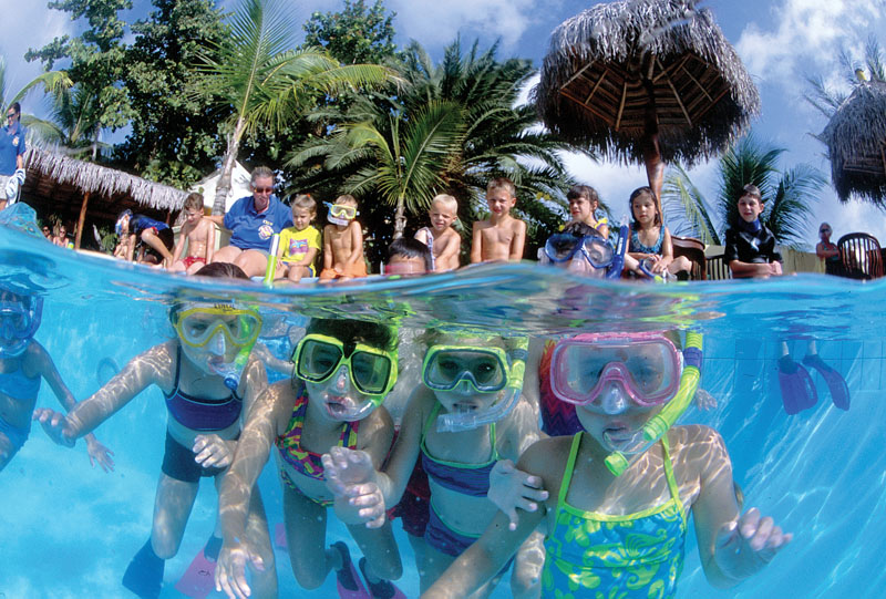 Young campers snorkelling together in shallow water
